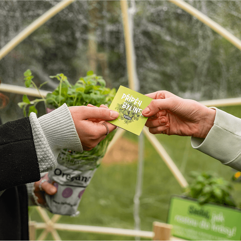 fotografie dvou rukou jak si podávají složený letáček