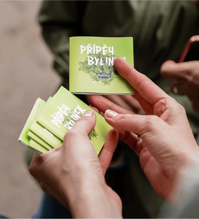 ruce s&nbsp;několika složenými letáčky